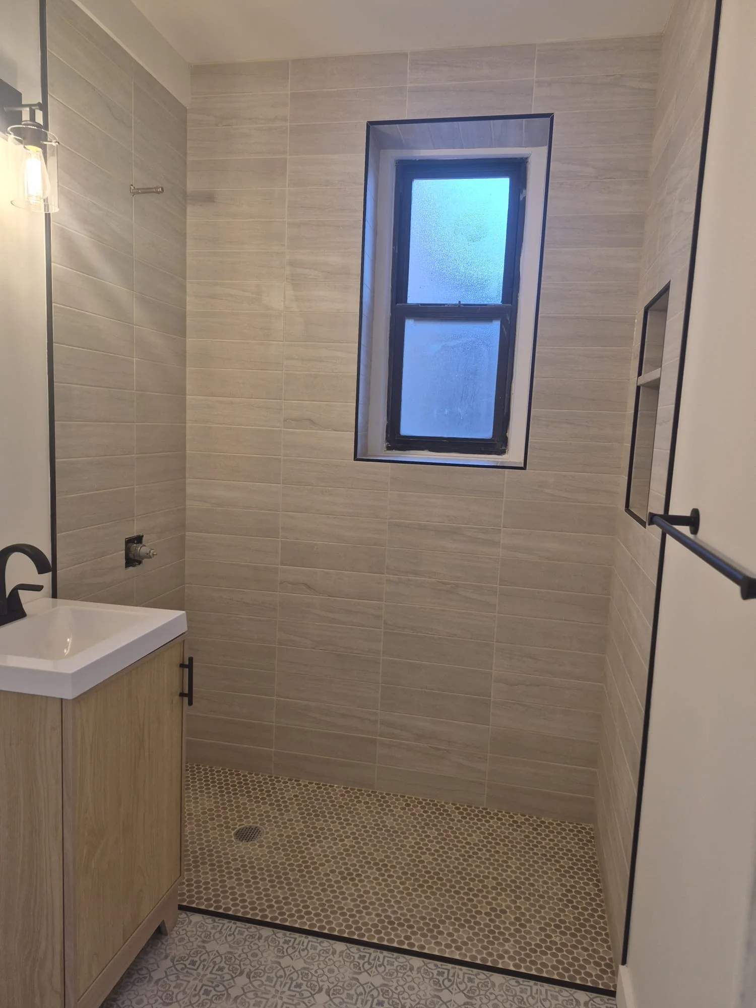 Pre-war Manhattan master bath remodel — Calacatta slab vanity, mitred shower walls, smart-shower controls