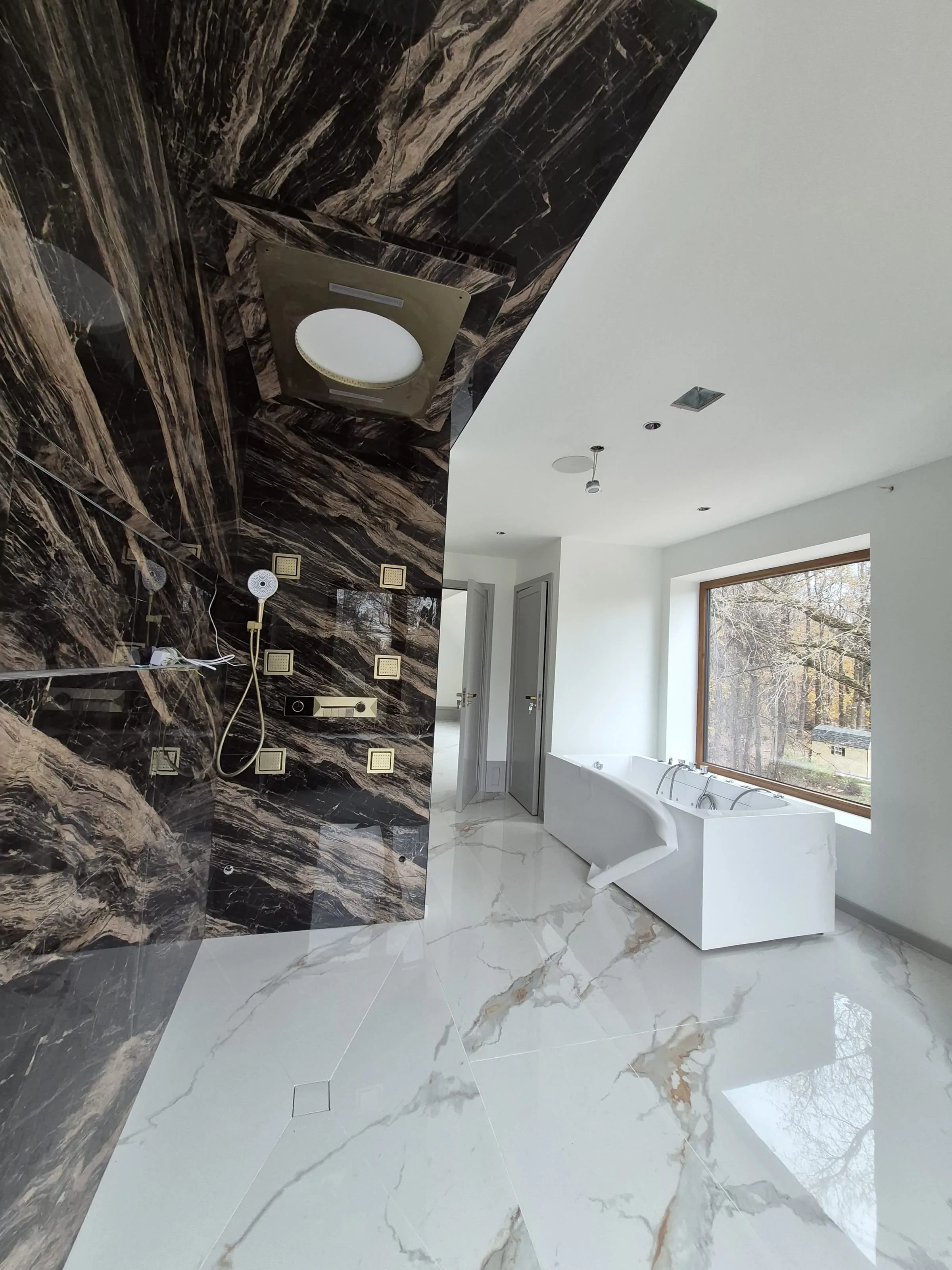 Luxury master bath with bookmatched marble walls and heated-mat-compatible polished marble floor — reference for tile-with-heated-floor installs